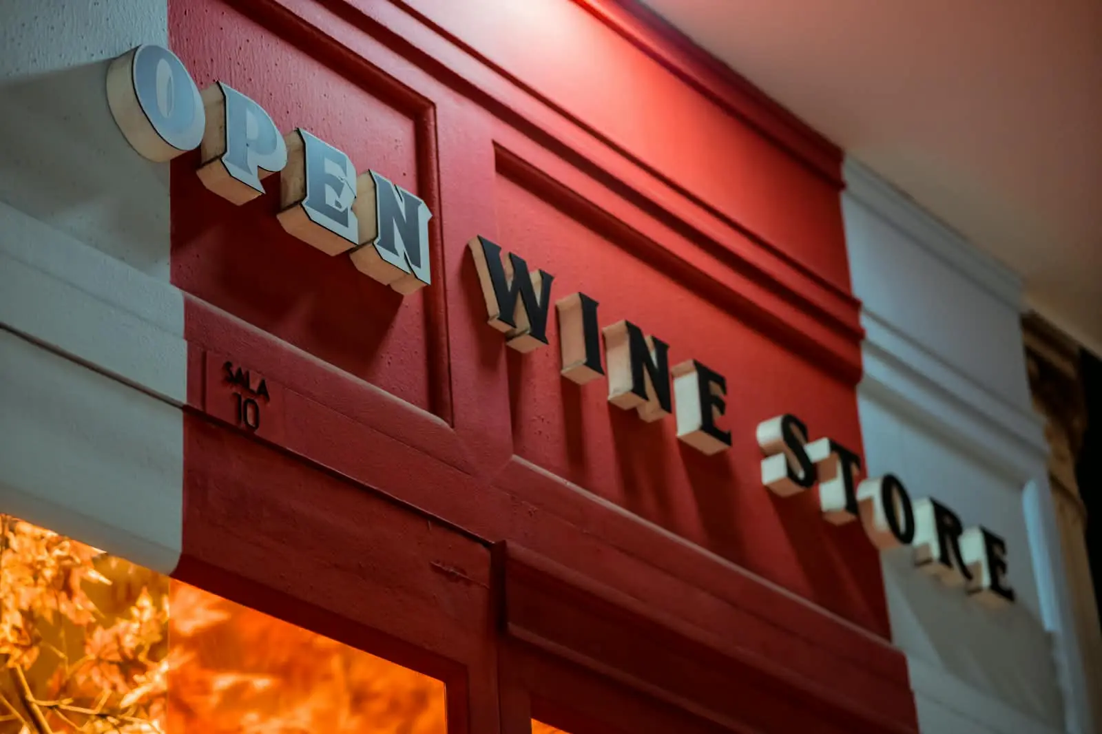 Letreiro Open Wine Store visto de baixo, em perspectiva